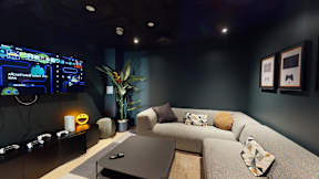 A modern living room with a large screen TV displaying a game interface.