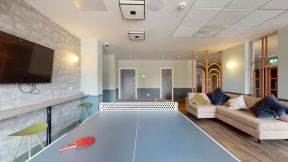 a room with a ping pong table and a couch