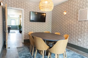 a dining room with a table and chairs and a tv on the wall