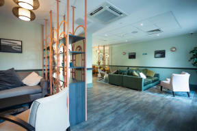 a living room with couches and chairs in a room with a wood floor