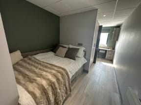 a small bedroom with a bed and a bathroom