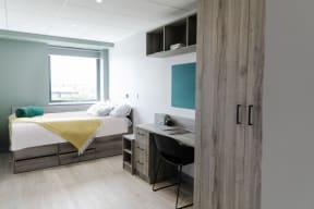 a small room with a bed and a desk and a window