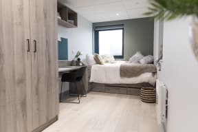 a bedroom with a bed and a desk in a small room