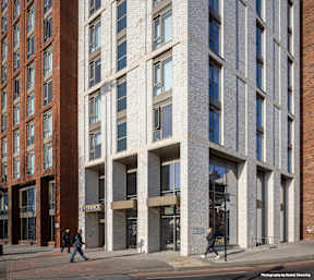 A tall building with a lot of windows and a sign that says "Entrance".
