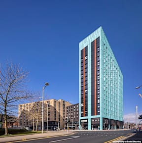 A modern glass building stands tall in the cityscape.