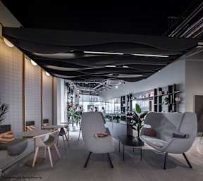 A modern cafe with white and grey furniture and a black ceiling.