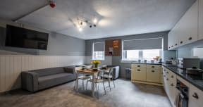 a living room and kitchen with a table and chairs