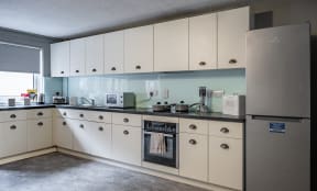 a kitchen with white cabinets and a stove and a refrigerator