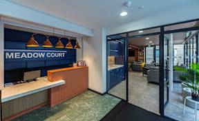 Meadow Court reception area with a blue wall and a brown counter.