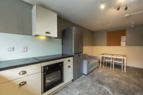 a kitchen and a dining room with a table and chairs