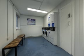 a laundry room with washers and dryers and a bench
