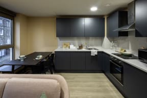 a small kitchen with black cabinets and a black dining table