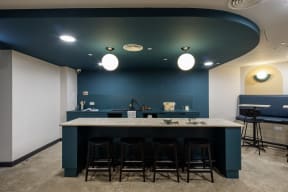 a bar with four stools in a room with a blue ceiling and white walls
