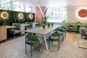 a dining room with tables and chairs and plants