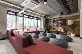 a living room with a red couch and pillows on the floor
