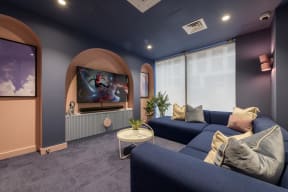a living room with blue couches and a tv