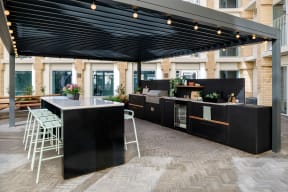 a large outdoor kitchen with a bar and stools