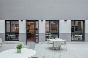 a communal area with tables and chairs and sliding glass doors