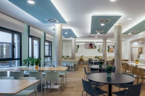 a large dining room with tables and chairs and windows