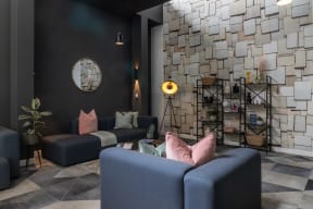 a living room with blue furniture and a stone wall