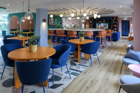 a restaurant with blue chairs and tables and a bar