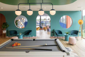 a pool table in a room with blue walls and chairs