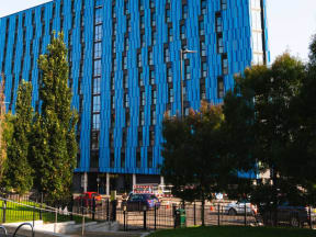 a tall blue building with trees in front of it