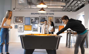 a group of people playing a game of pool at bounce wall of fame