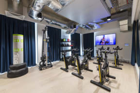 a group of exercise bikes in a room with a tv