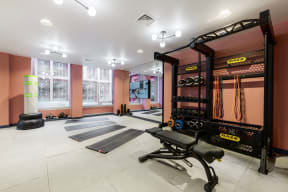 a home gym with weights and mats on the floor and a large window
