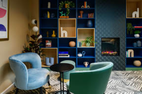 a living room with blue chairs and a blue shelf with a fireplace