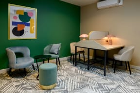 a room with a table and chairs and a painting on the wall