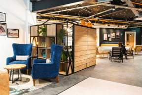 a lobby with blue chairs and tables and a wooden