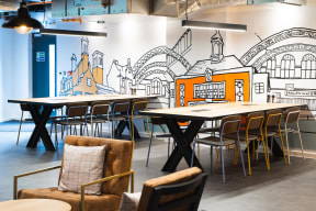 a dining room with tables and chairs and a mural on the wall