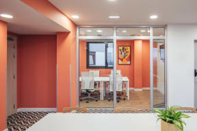 a conference room with orange walls and white tables and chairs