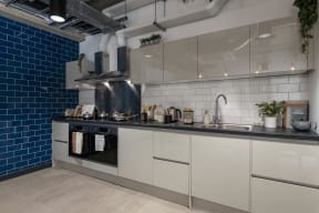 a kitchen with white cabinets and blue tiles