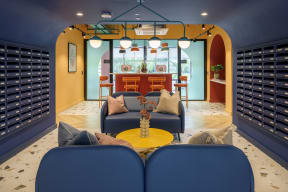 a living room with blue couches and a yellow table and wine racks