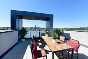 a roof top terrace with a wooden table and chairs