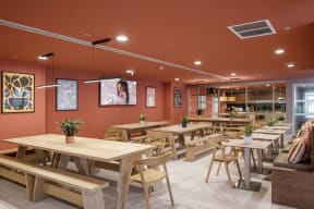 a restaurant with wooden tables and chairs and orange walls