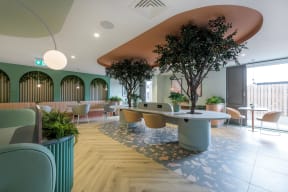 a large room with tables and chairs and plants in it