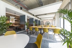 a large dining room with yellow chairs and tables