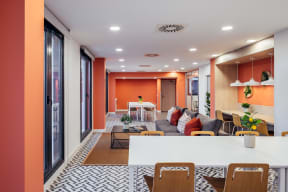 a living room with orange walls and a white table and chairs