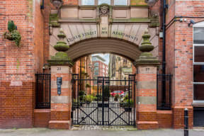 the entrance to the archway of a brick building with an iron gate