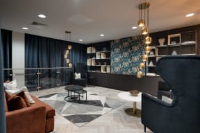 a lobby with couches and chairs and a wall with a tapestry