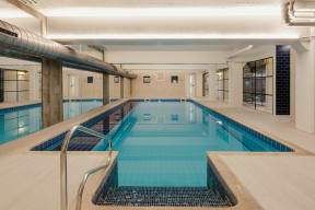 a swimming pool in a large room with a railing around it