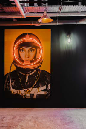 a mural of a woman wearing an astronaut helmet on a wall