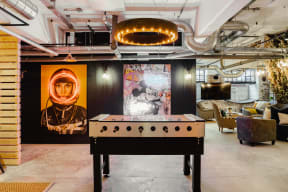 a pool table in a living room with a mural and a projector
