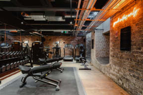 a gym with weights and a brick wall