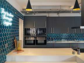 A modern kitchen with a white countertop and black cabinets.