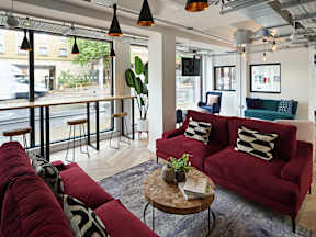 A living room with a red couch and a coffee table.